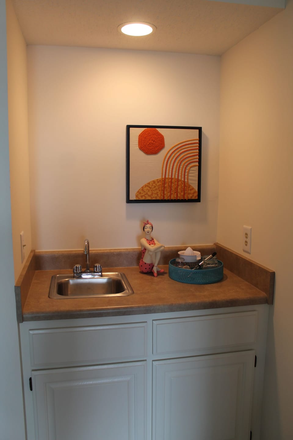 Wet bar with a library of books underneath. 
