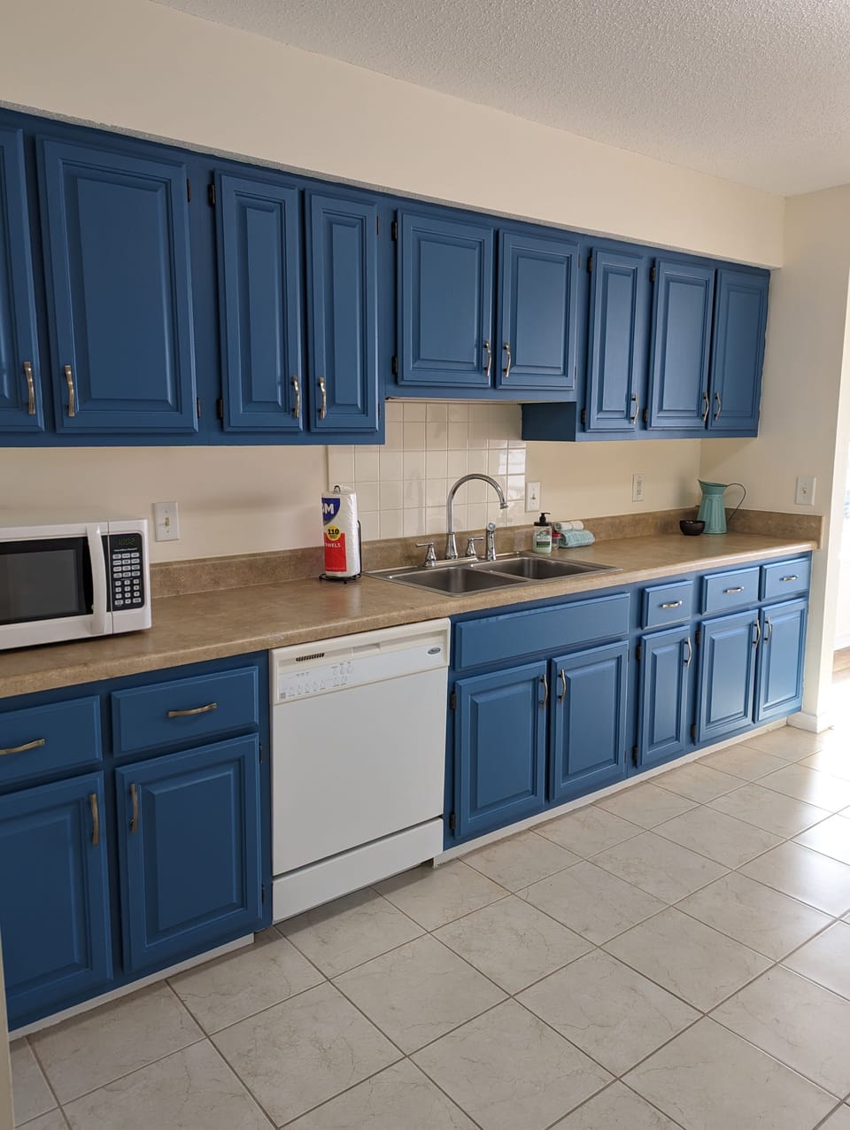 Large kitchen, fully stocked with dishes, pans, basic appliances, and silverware