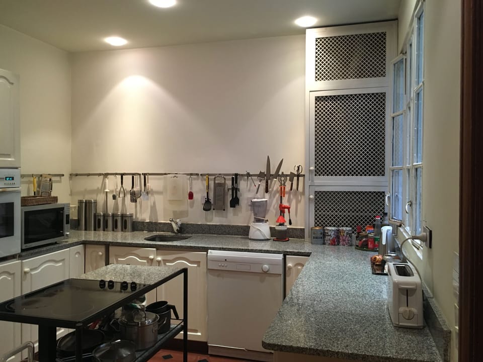 Kitchen with cooking island, dishwasher, oven, electric kettle, coffee makers.