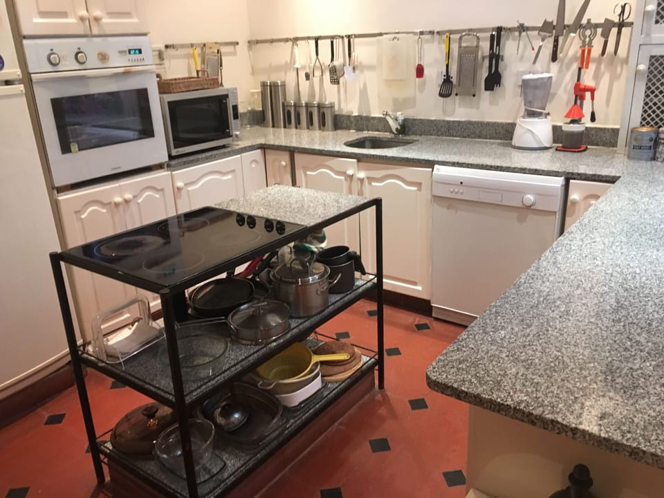 Kitchen with electric oven, cooktop in island, microwave, blender, toaster & all