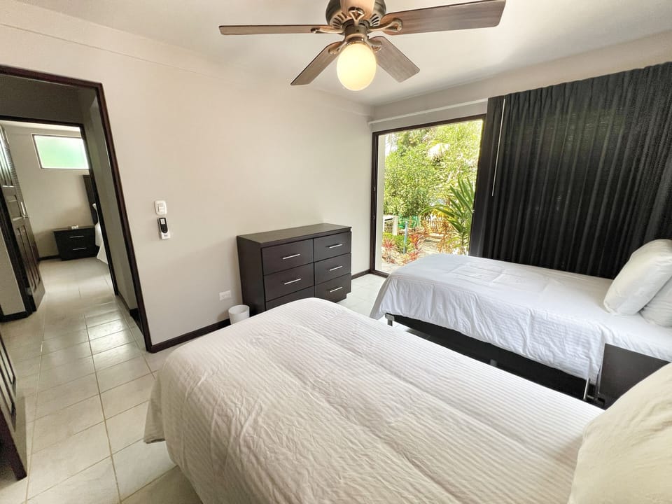 The lower level twin bedroom has a dresser, closet, and access to the yard through sliding patio doors.   Though the headboards don't move, these beds can be configured as a King bed on request.   