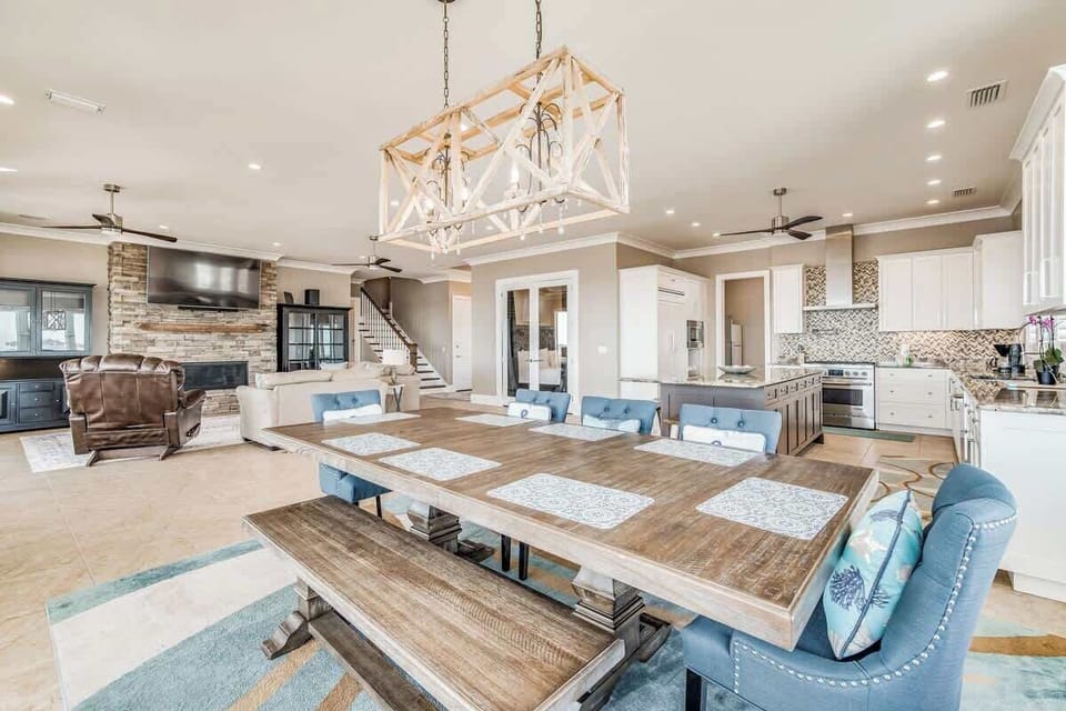 Spacious dining table with a fully equipped kitchen next to it.