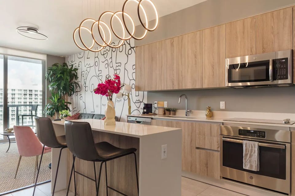 The kitchen island features chic seating and artistic touches.