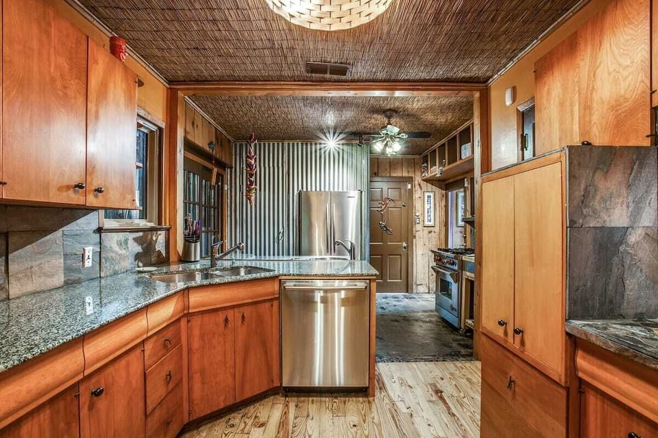 Double kitchen sink, dishwasher, Wolf gas stove & oven, counter & cabinet area. 