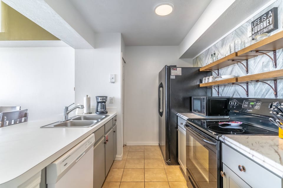 Fully equipped kitchen with electric stove and oven, drip coffee maker, refrigerator, microwave, dishwasher and more!