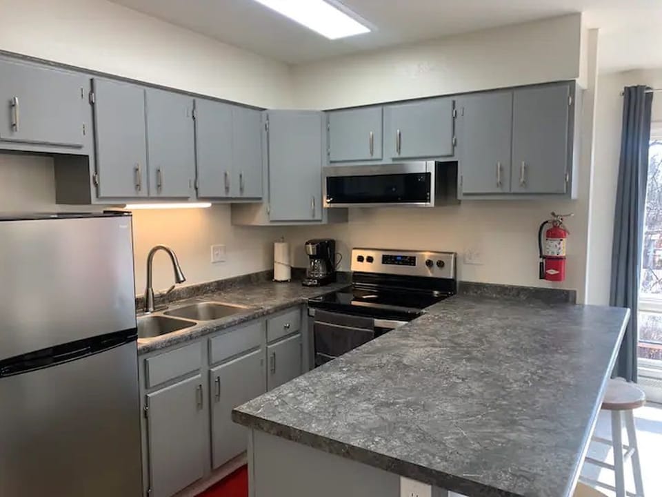 Fully stocked kitchen with drink ware, dishes, cooking utensils and pots/pans. 