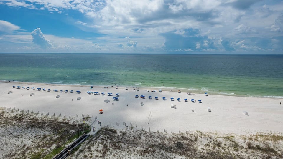 Colorful umbrellas lining the shore, inviting you to relax and soak up the sun
