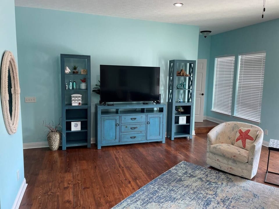 Another view of the recently renovated living room with a large television.  The door in the background leads to the third floor primary suite for total privacy.  I should have opened the blinds because the gulf is right outside the windows.