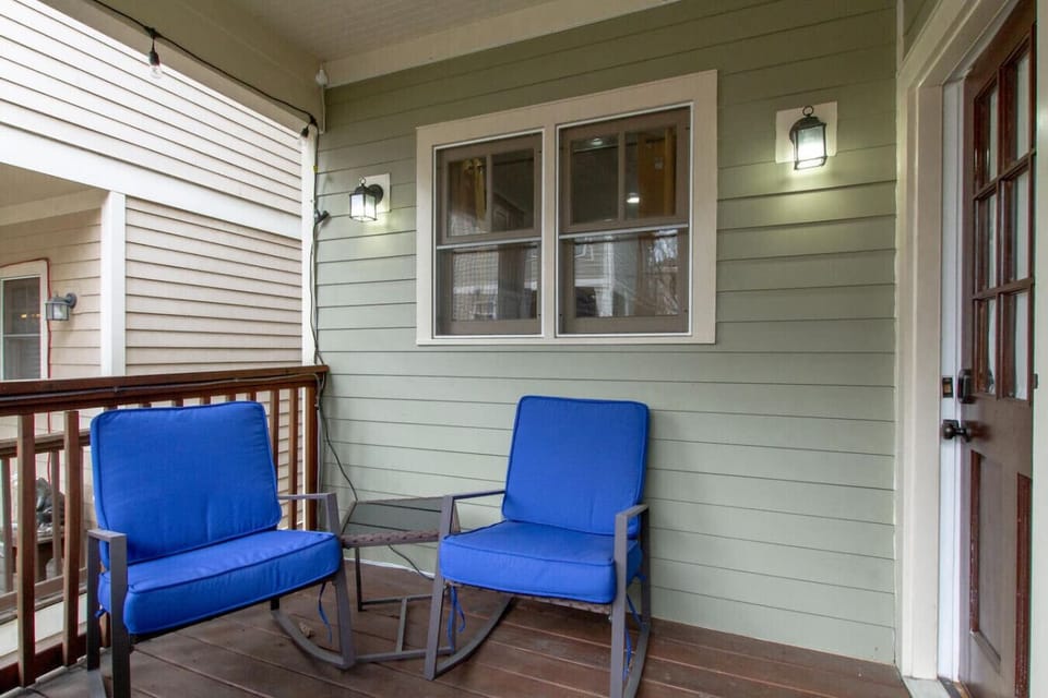 Inviting front porch with sage green siding and warm lighting.