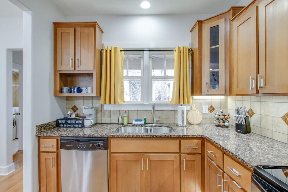 A warm and welcoming kitchen with golden curtains and light wood.