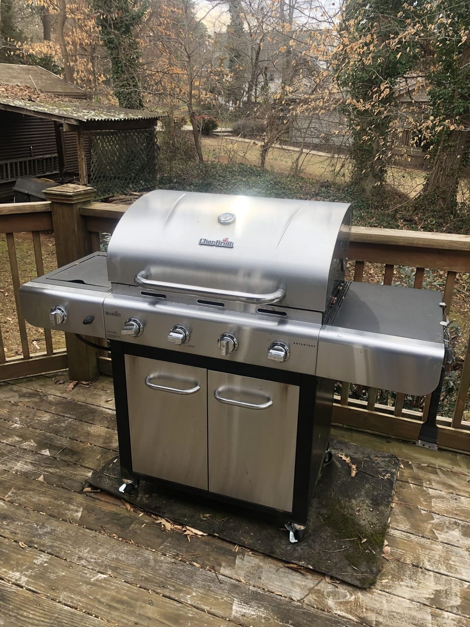 Large gas grill located next to screened porch