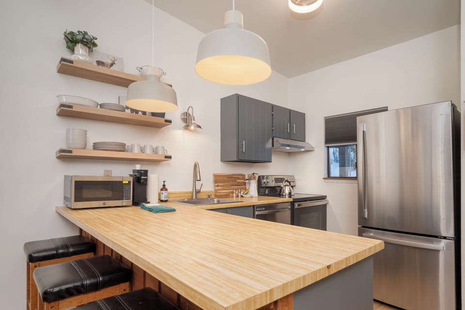 Your modern kitchen features bamboo counters, stainless appliances, and cozy breakfast bar seating for memorable meals together.