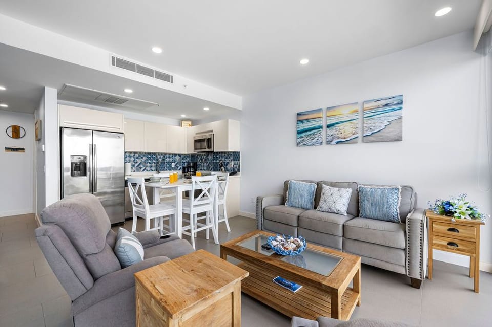 Bright open space blends living and dining, perfect for your seaside escape. Relax on plush sofas, dine together, and enjoy a modern kitchen ready for your coastal stay.