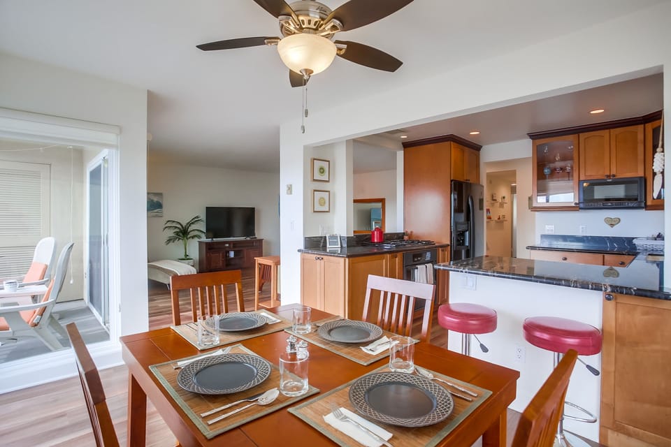 Dining table for four people and bar seating for two people.