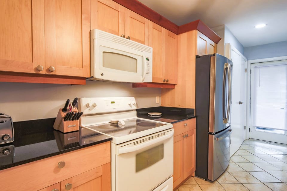 The kitchen features a refrigerator, range, microwave, toaster and more.