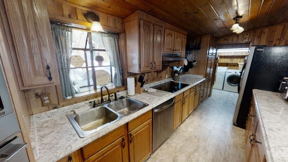 Step into your fully-equipped kitchen with warm wood cabinetry, granite counters, and modern appliances—perfect for preparing home-cooked meals during your stay.