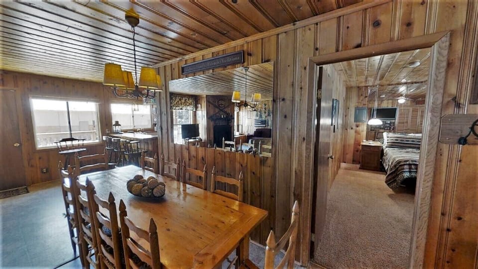 Warm wood paneling and cozy rustic charm greet you in this inviting space. A welcoming dining area flows naturally into comfortable bedrooms, perfect for gathering and relaxing during your mountain getaway.