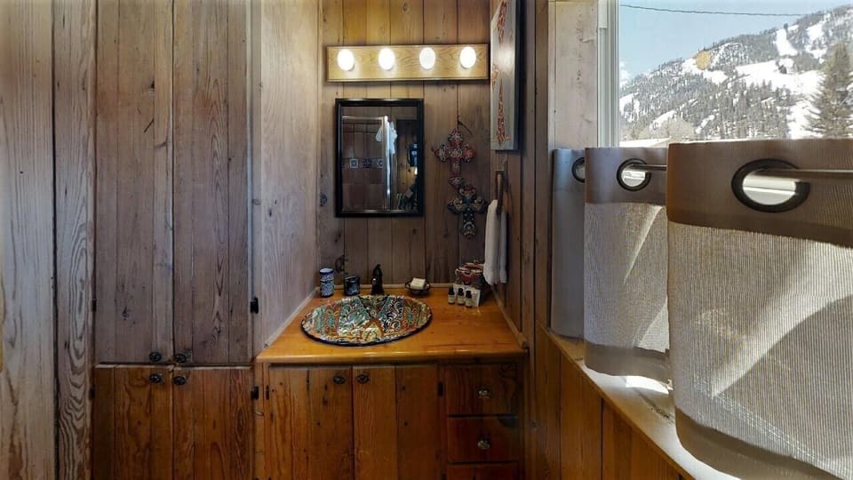 Wake up to stunning snowy mountain views from your private bathroom. The rustic wood vanity and unique vessel sink add character to your morning routine while you soak in the alpine scenery.