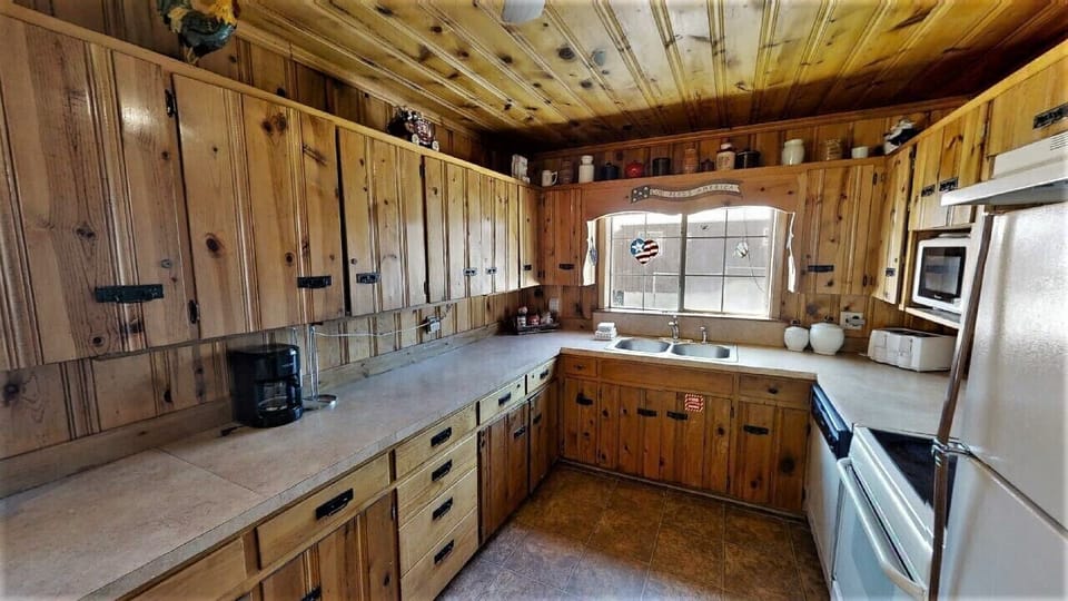 Step into this cozy, rustic kitchen where warm pine cabinetry and ample counter space invite you to prepare home-cooked meals surrounded by charming cabin character.