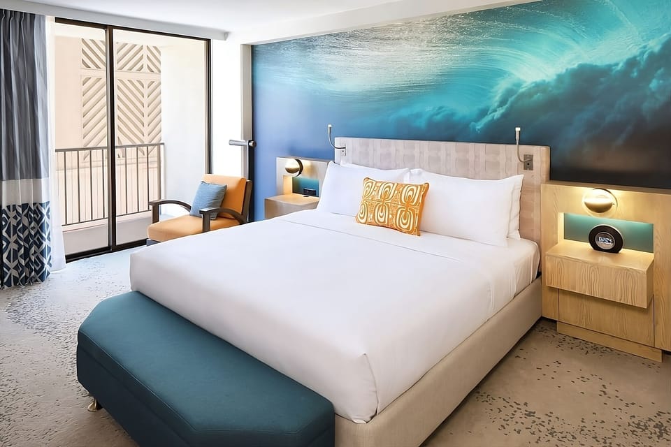 Sink into crisp linens beneath a calming ocean mural.