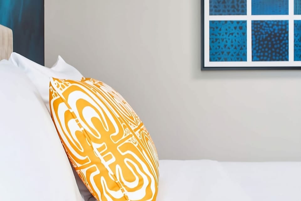 Sink into crisp linens with playful island-inspired pillows.