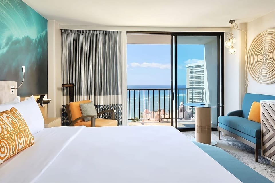 Breathe in sea air from bed with balcony beyond.