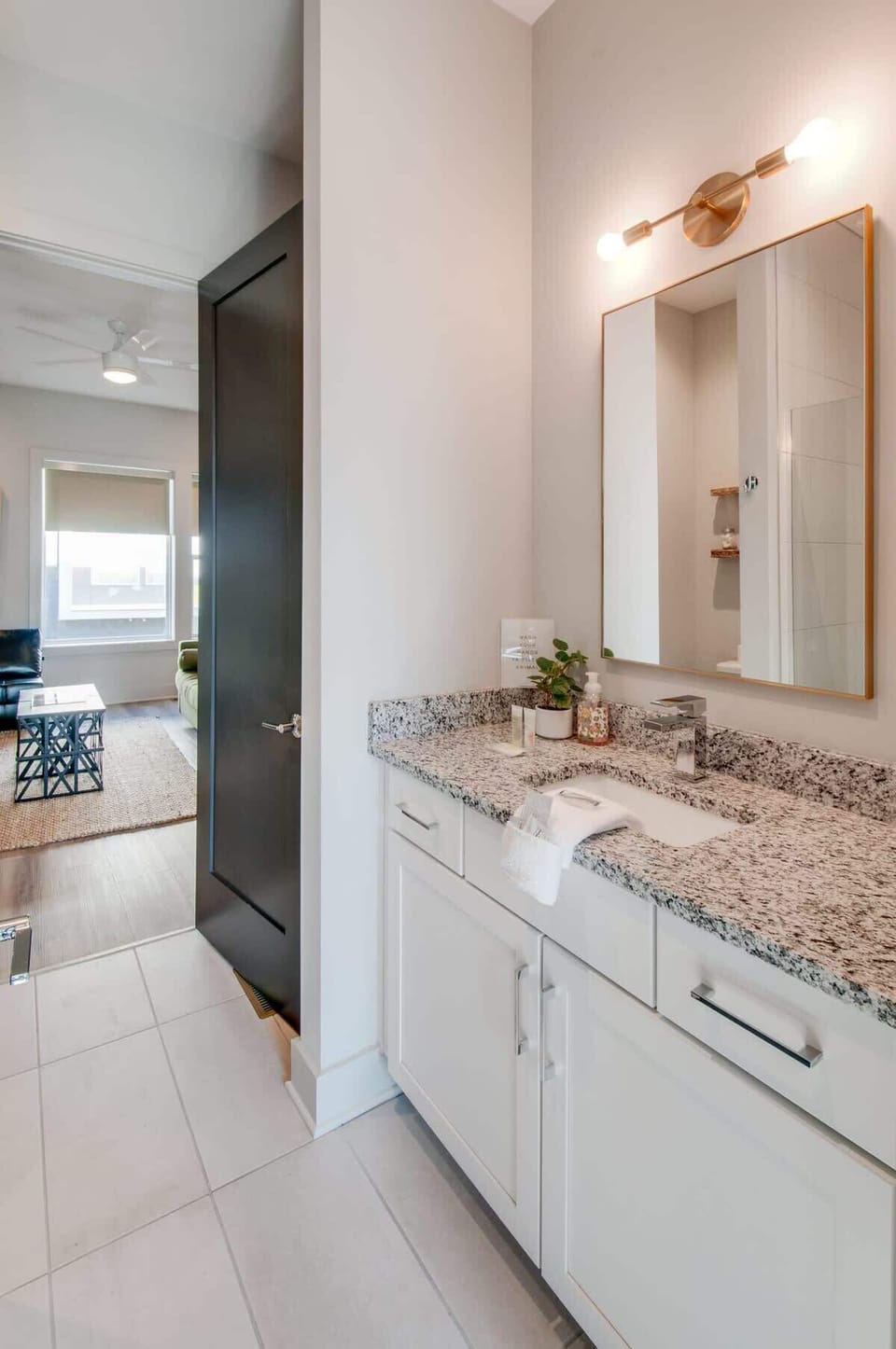 Single vanity with granite countertop and clean mirror in one of four full bathrooms, so nobody's waiting in line before heading out