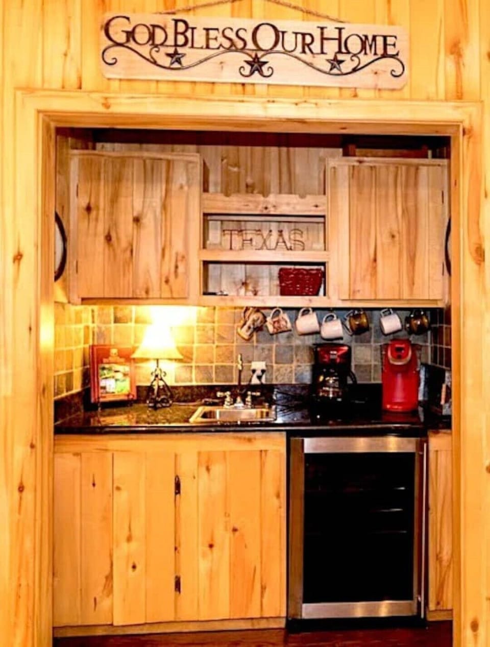 Beverage station with Keurig, coffee pot, beverage chiller, glasses, and mugs.