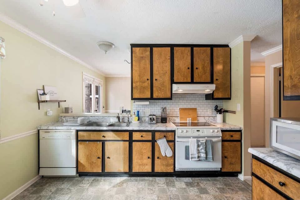 Fully equipped kitchen with dishwasher, oven, stove, microwave, toaster, and fridge. Plates, bowls, cups, pots, pans, utensils, and other cookware can be found here for all cooking needs.