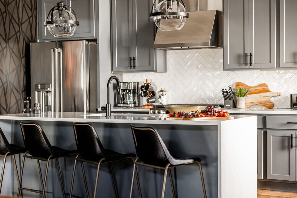 Bright open kitchen with professional stainless steel appliances and modern furnishes.