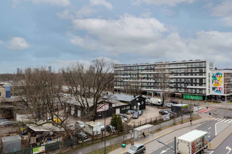 View from the balcony over the surrounding area. View of street and distant buildings.