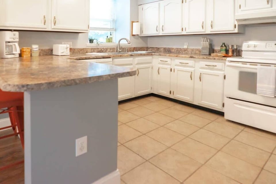 This stunning kitchen with white cabinets and a sleek countertop is just the place to whip up your favorite meals! 🍽️✨