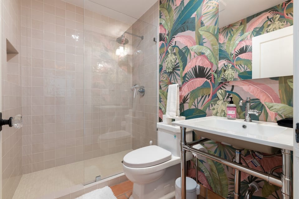 2nd Bathroom is fun and tropical with the brightly covered wallpaper. It also has a step in shower.