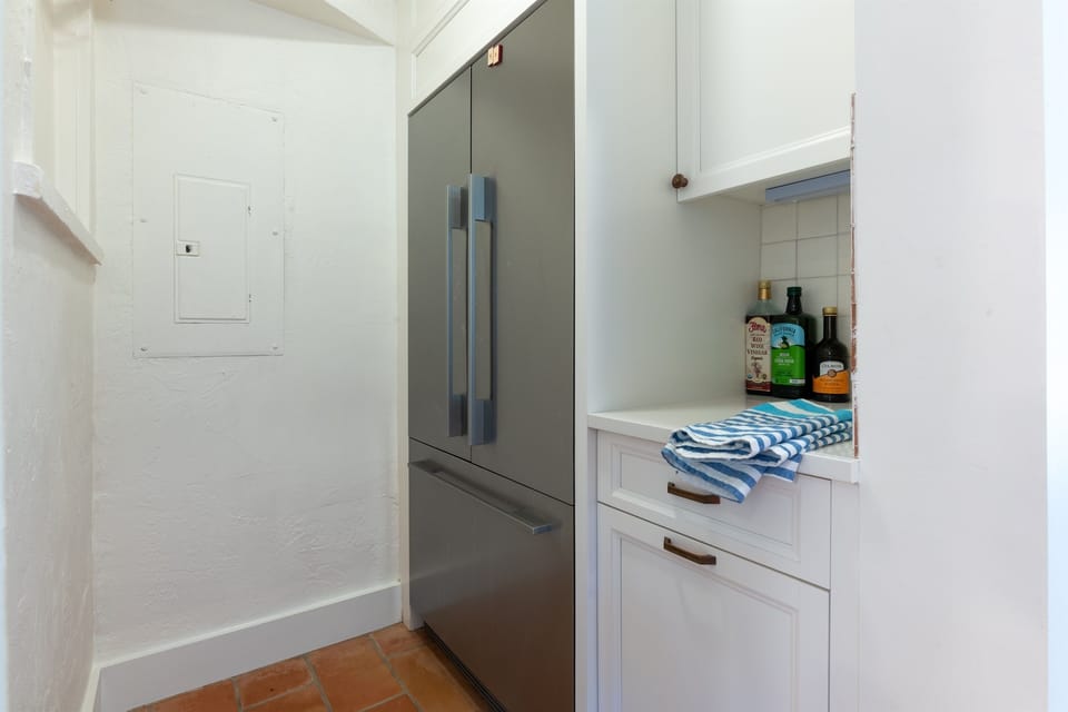 Gorgeous newly upgraded kitchen with stainless steel double door refrigerator, white Farmhouse style gas range, stove, Nespresso Vertuo 3 coffee maker, toaster and new white counter tops.