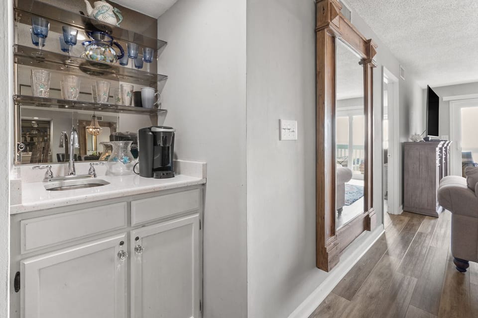 Mirrored shelves, a coffee maker and white cabinetry at Coastal Shores C2, an Ocean Drive condo rental