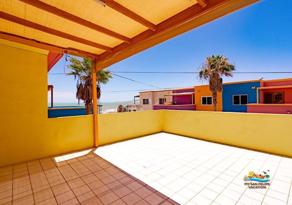 This upstairs balcony patio offers outdoor seating and a partial neighborhood view — a quiet spot to relax just steps from the beach and a short walk to the Malecon.