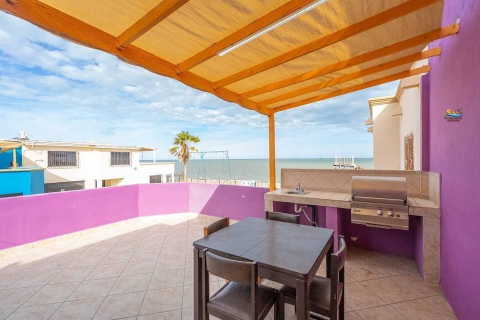 The balcony features a BBQ grill and outdoor seating — perfect for cooking while enjoying ocean views, just steps from the beach and a short walk to the Malecon.