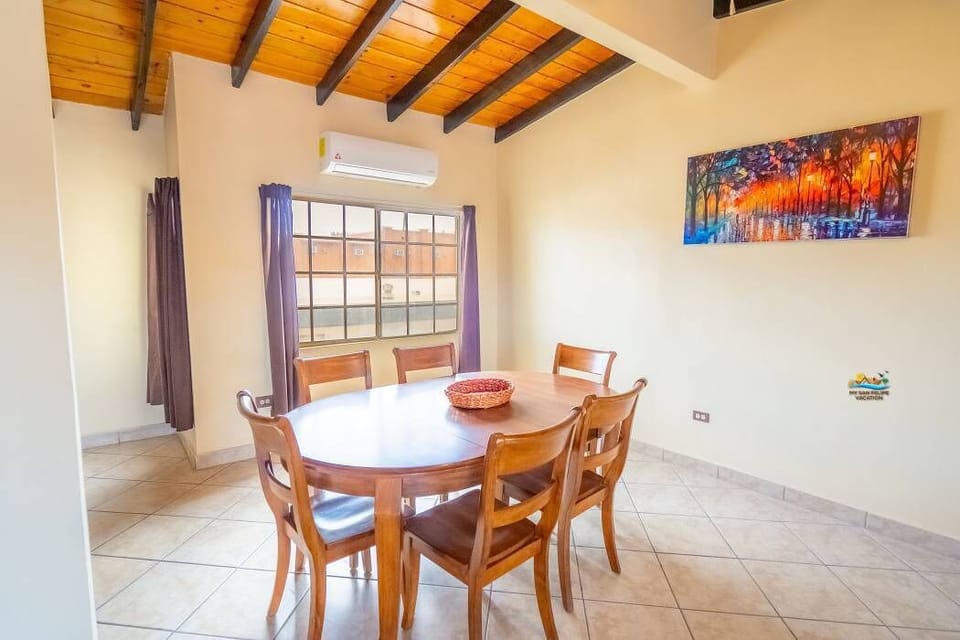 This view of the dining table highlights its open connection to the living room and kitchen — a central spot for group meals just steps from the beach.