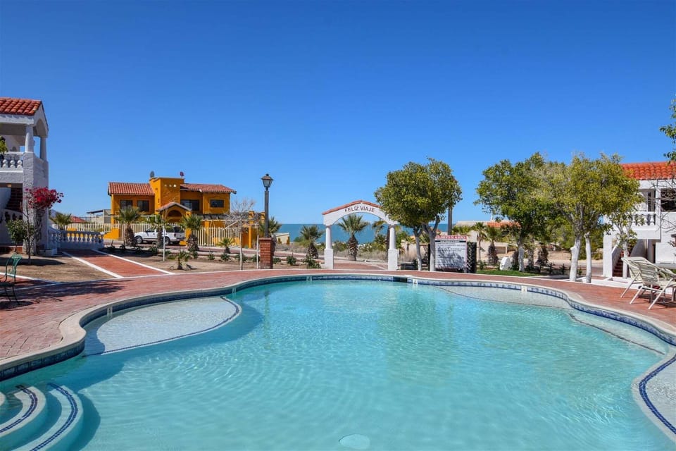 A crystal-clear community swimming pool surrounded by a spacious deck, perfect for cooling off and enjoying the beautiful Baja sun.