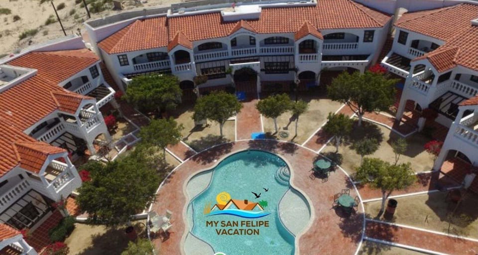 A stunning drone-captured overhead view showcasing La Hacienda Condo 6 along with the neighboring properties, highlighting the spacious layout and prime location within the community.