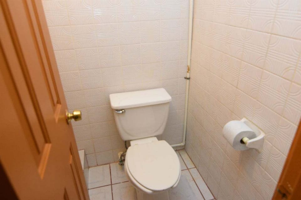 Private bathroom with toilet and bathtub — located 2 miles north of the San Felipe Malecon with secured parking, A/C, and free WiFi .