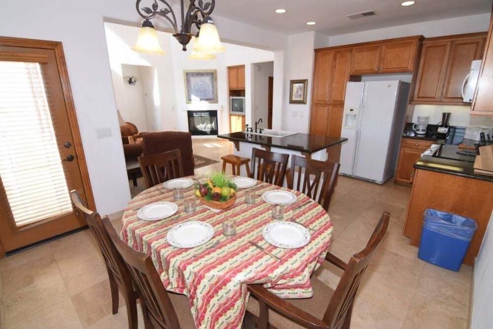 This spacious 2-bedroom, 2-bath vacation rental features a fully equipped kitchen, adjacent dining table, and comfortable living room with fireplace and flat-screen TV — all in an open concept floor plan.