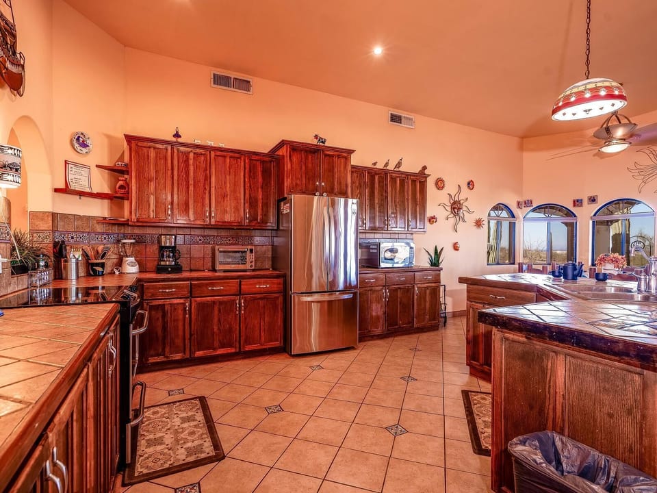 The kitchen at Casa Zur Heide features an island with bar stools, modern appliances, and flows into the dining area — perfect for meal prep and casual dining in this 3-bedroom rental home.