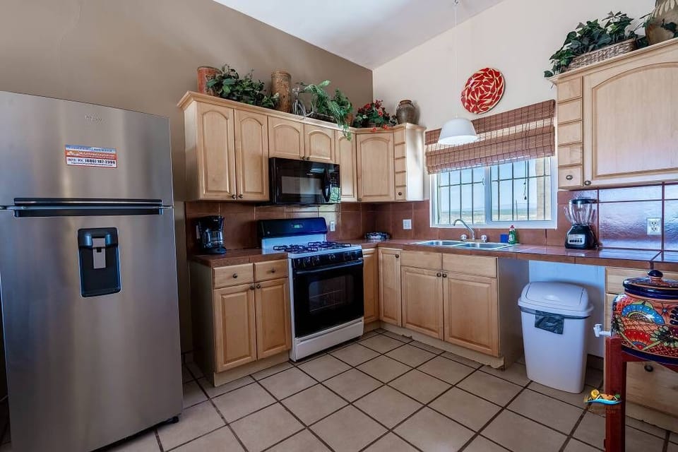 This Casita de Playa kitchen includes a full-size refrigerator, oven, microwave, coffee maker, and all essential cookware — everything needed to prepare meals during your stay