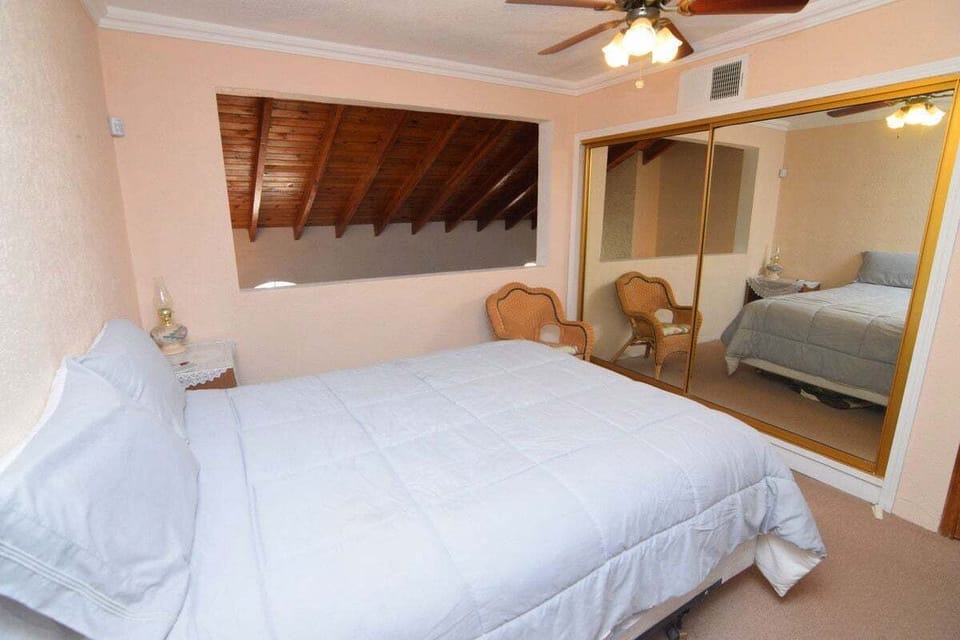 Stunning queen master suite on the second level with a walk-in shower, private commode, elegant vanity, spacious closet, reading chair, and large sliding glass windows with city views.