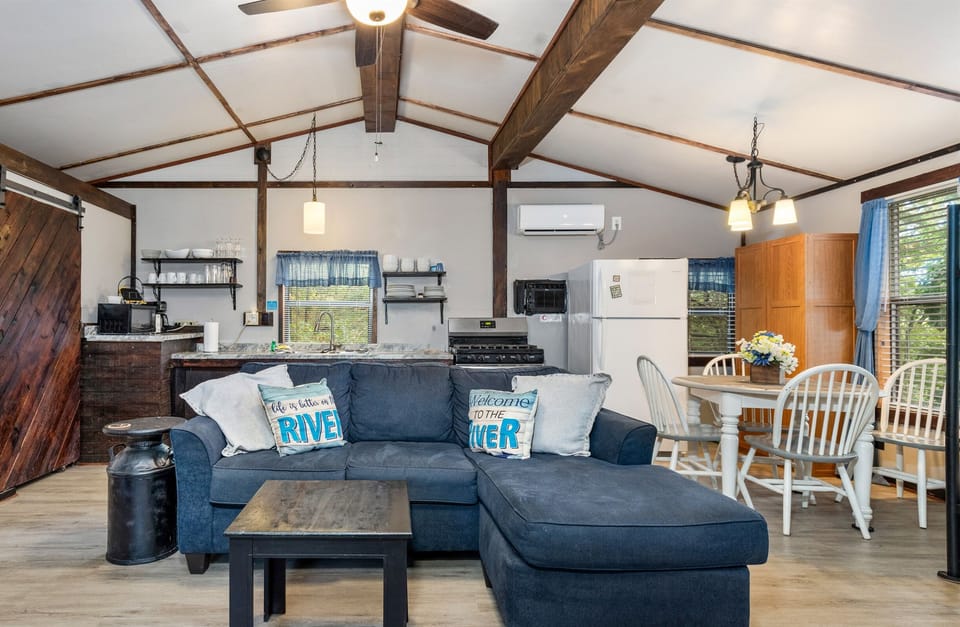 Studio Cabin with full kitchen, dining table, couch, beds, and smart TV. 