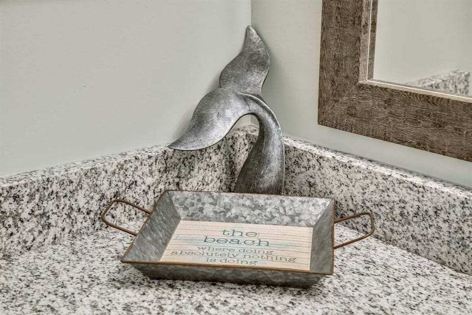 Coastal accents on the counter add a small, thoughtful touch to the bathroom space.