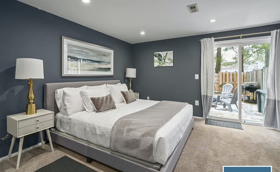 Basement: Master bedroom`s king-sized bed accompanied w/ table lamps -ideal for reading-