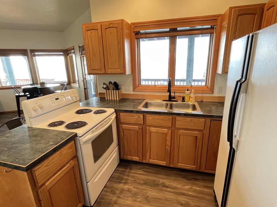 Downstairs kitchen is open to living room and dining area and faces the lake. 