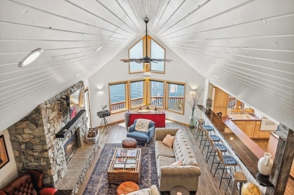 Spacious, open and bright living room looking out at the lake. View from loft.